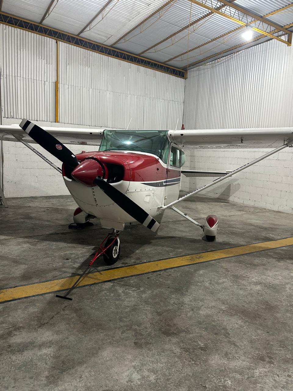 Red and white Cessna aircraft in hangar