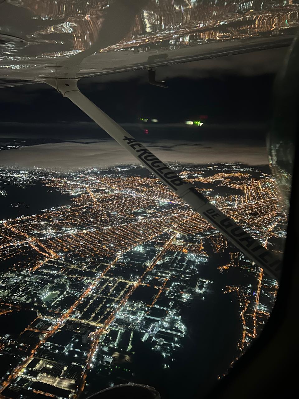 Night aerial view of Guatemala City lights from Aeroclub aircraft